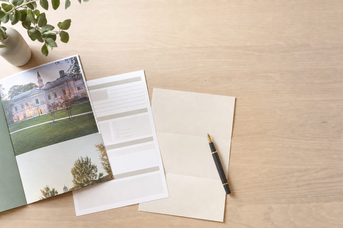 Admission Essay — university prospectus, a printed application form and a fountain pen on a folded letter