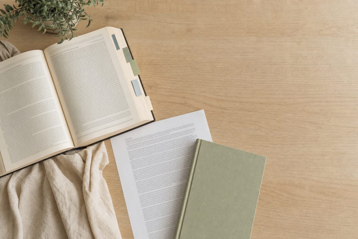 Political Essay — legal casebook open with sticky tabs, a printed statute page and a plain notebook